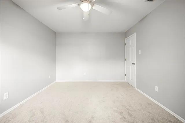 a view of an empty room with a chandelier fan