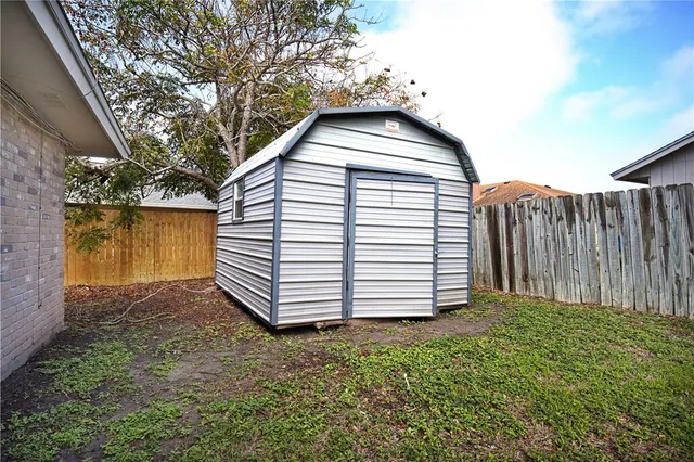 a view of a house with a yard and wooden fence