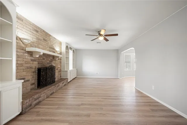 a view of an empty room with a fireplace and a window