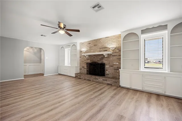 an empty room with windows and fireplace
