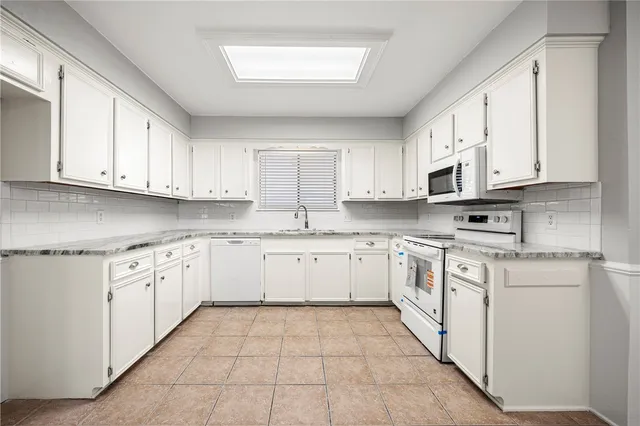 a kitchen with cabinets appliances a sink and a window