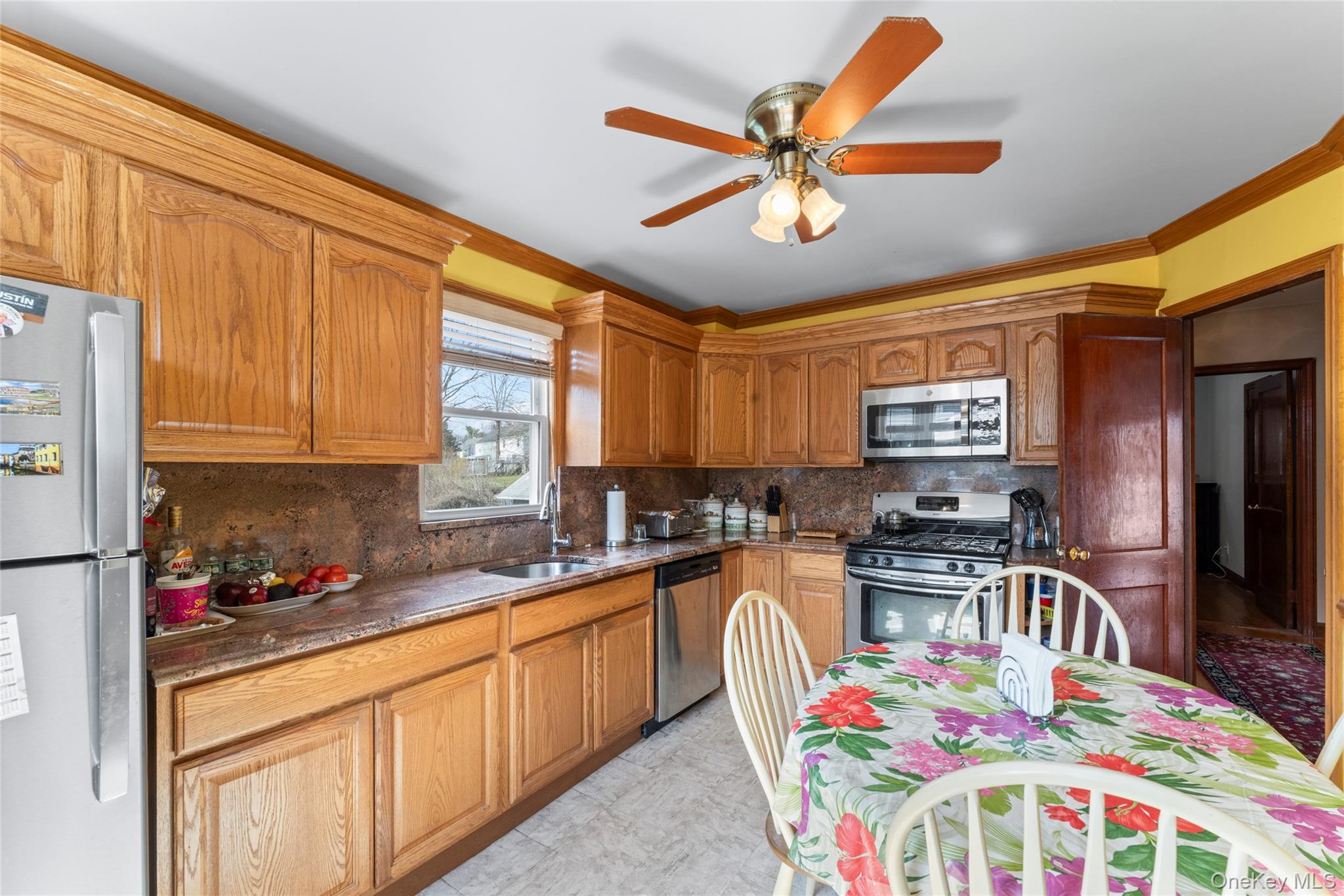 18 Butler Place Yonkers, NY 10710 - Photo 11 of 46 a kitchen with stainless steel appliances a sink a stove a dining table chairs and a refrigerator