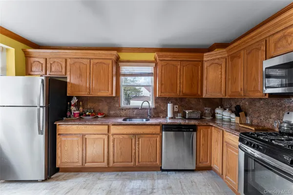 a kitchen with stainless steel appliances granite countertop a stove a sink dishwasher and a refrigerator