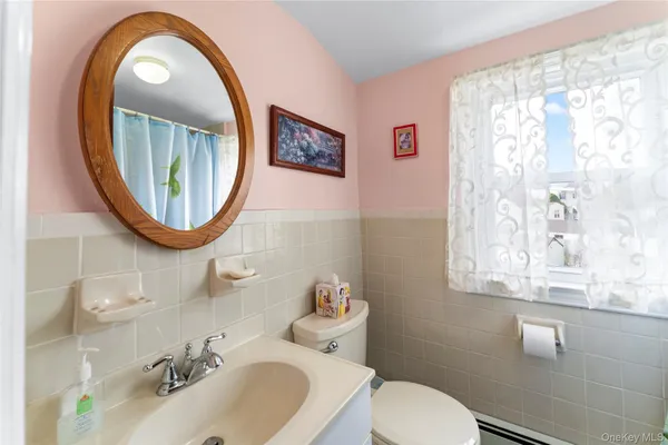 a bathroom with a toilet sink and mirror