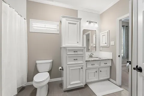 a bathroom with a toilet a sink and mirror