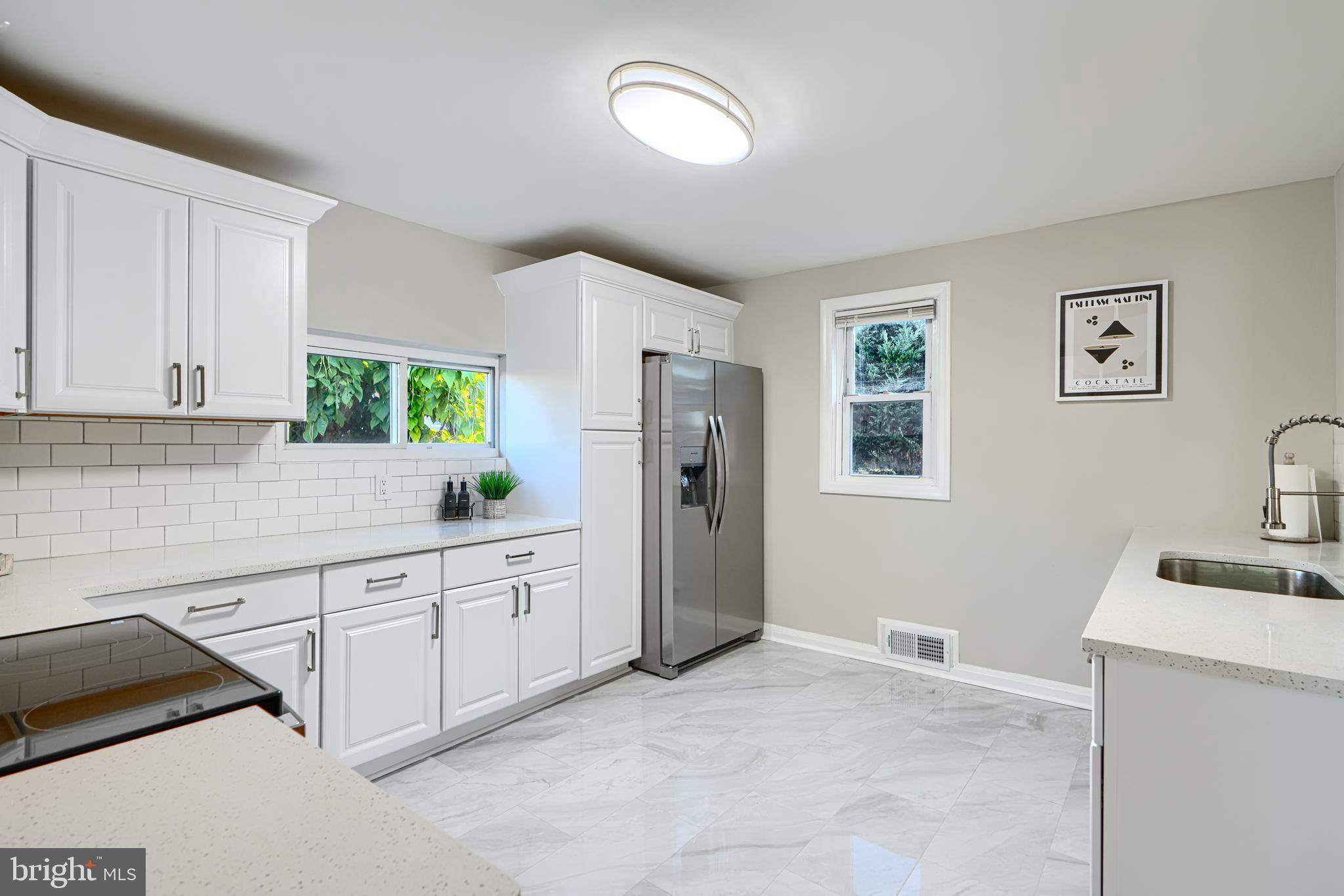 3515 Rhom Road Gwynn Oak, MD 21207 - Photo 12 of 36 a kitchen with granite countertop a refrigerator sink and white cabinets