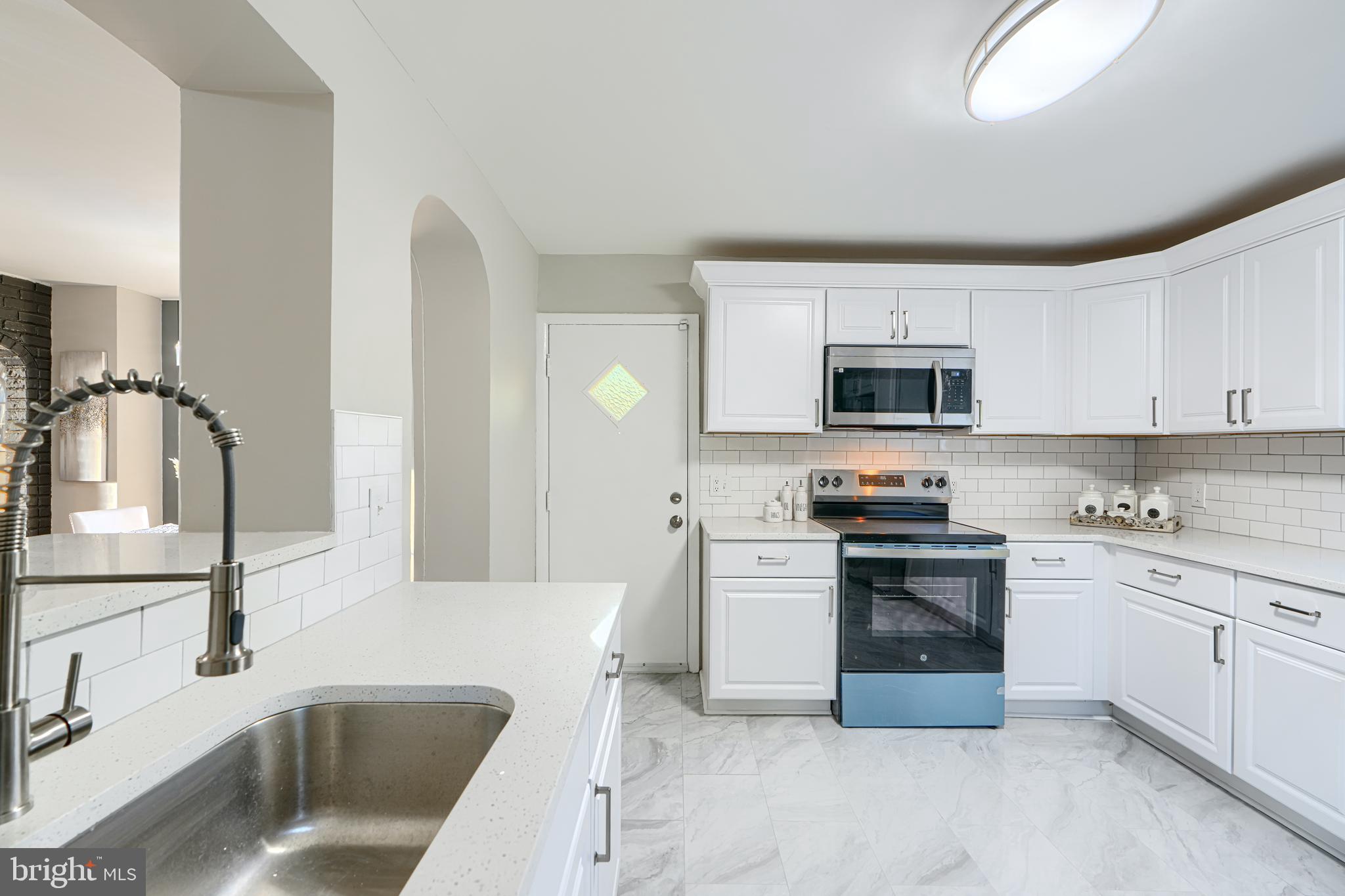 3515 Rhom Road Gwynn Oak, MD 21207 - Photo 14 of 36 a kitchen with stainless steel appliances granite countertop a sink stove and microwave