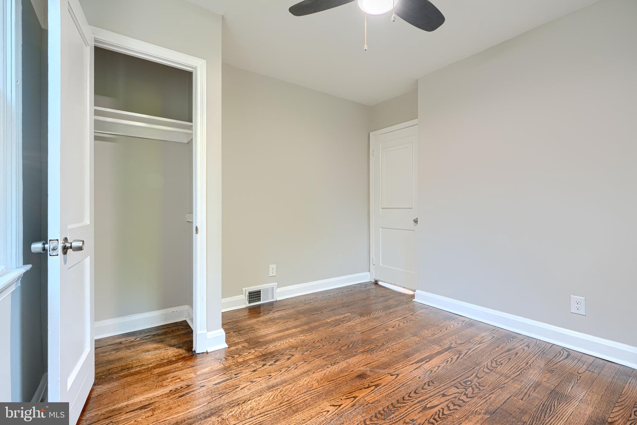3515 Rhom Road Gwynn Oak, MD 21207 - Photo 20 of 36 an empty room with wooden floor closet and chandelier fan