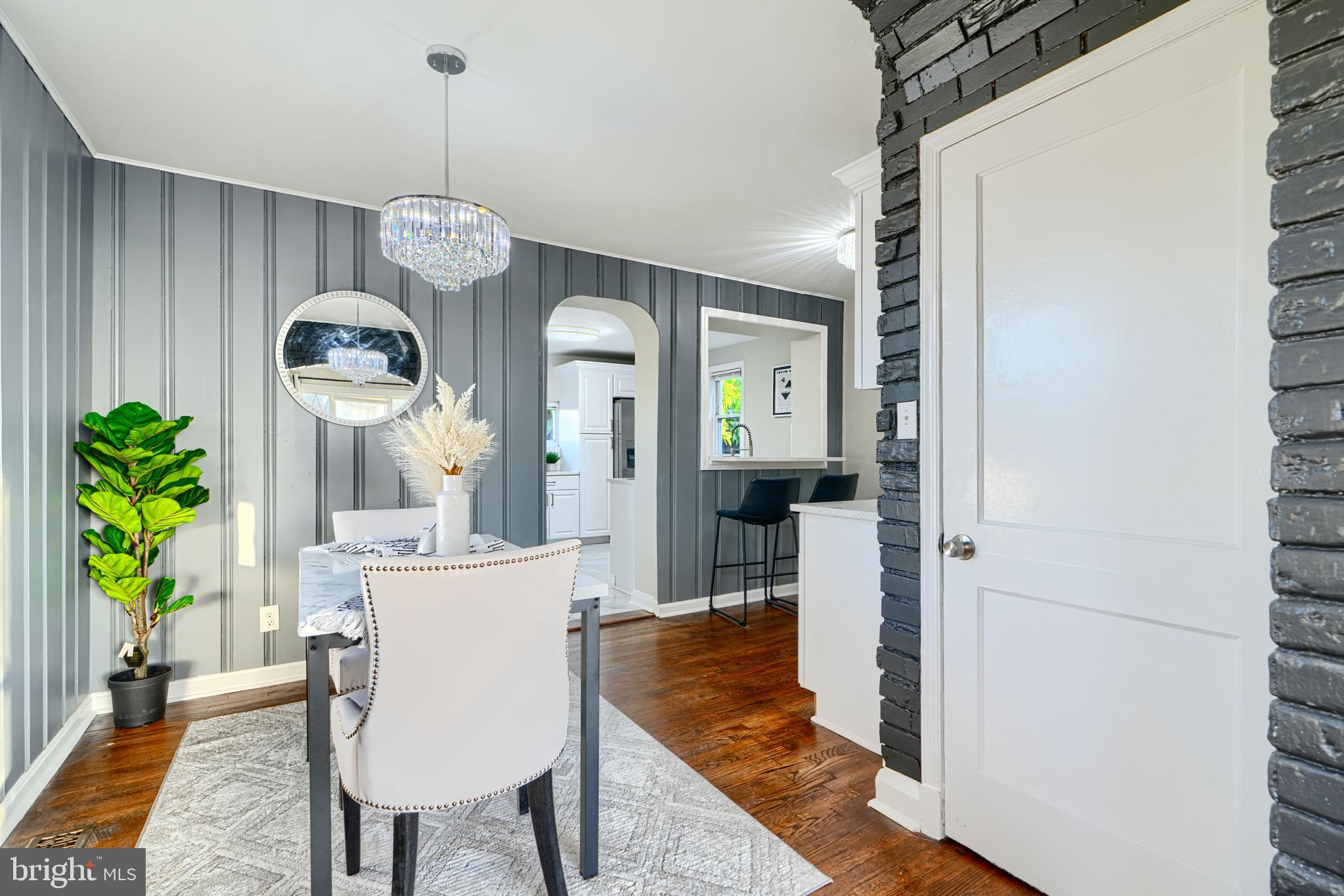 3515 Rhom Road Gwynn Oak, MD 21207 - Photo 8 of 36 a dining room with wooden floor a chandelier a wooden table and chairs