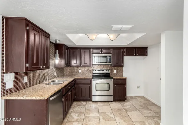 a kitchen with stainless steel appliances granite countertop a stove sink microwave and cabinets