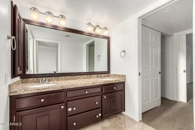 a bathroom with a granite countertop sink and a mirror