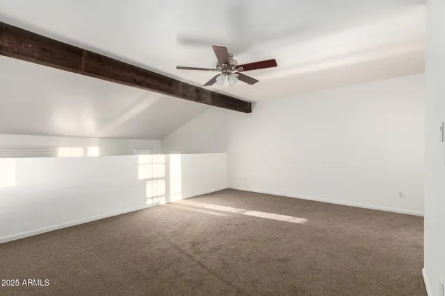 an empty room with a ceiling fan and window