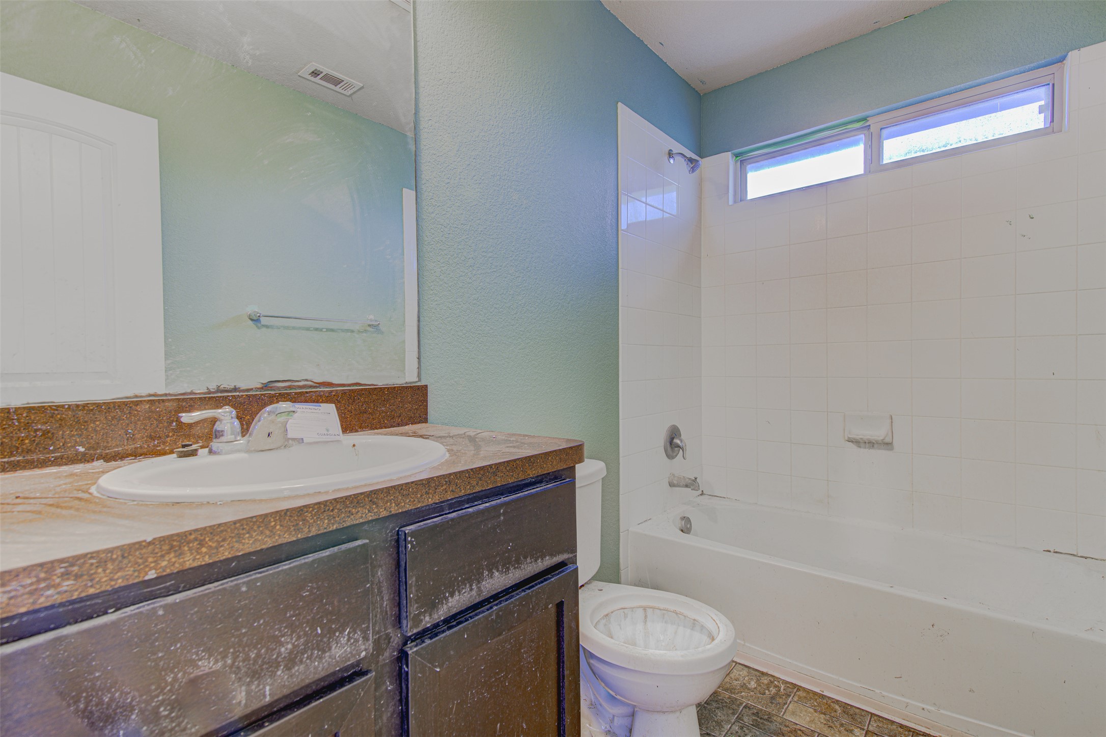 4527 Kind Way, Unit 231 Austin, TX 78725 - Photo 13 of 18 Bathroom featuring a vanity with an integrated sink, a dark countertop, and a full-width mirror