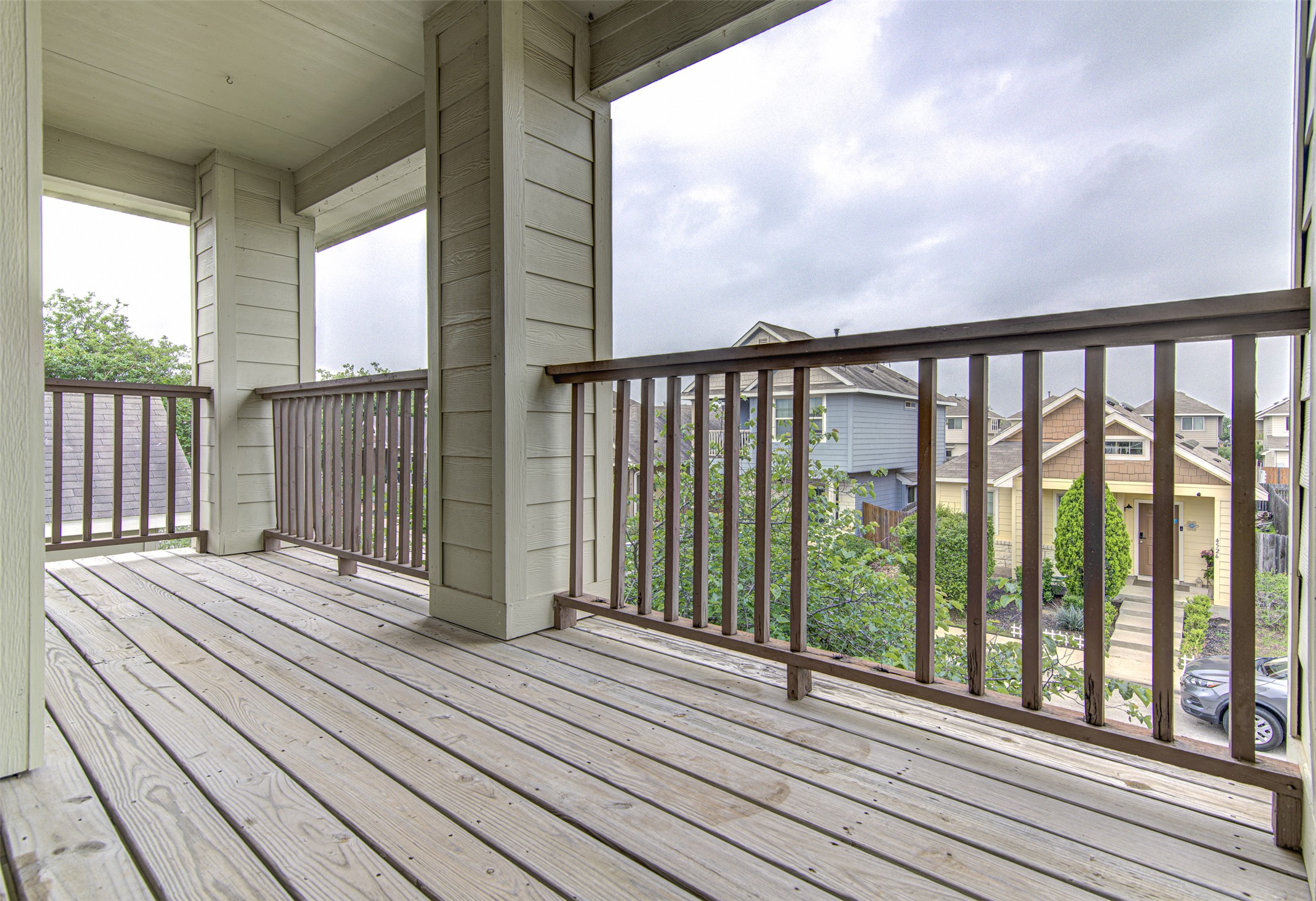 4527 Kind Way, Unit 231 Austin, TX 78725 - Photo 14 of 18 Expansive outdoor balcony featuring natural wood decking and dark wood railings