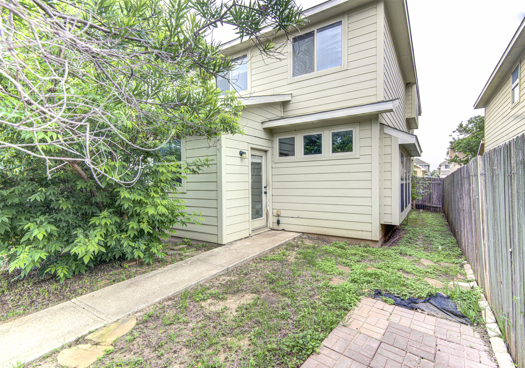 4527 Kind Way, Unit 231 Austin, TX 78725 - Photo 17 of 18 Two-story exterior featuring horizontal siding, multiple windows, and a paved walkway leading to an entry door