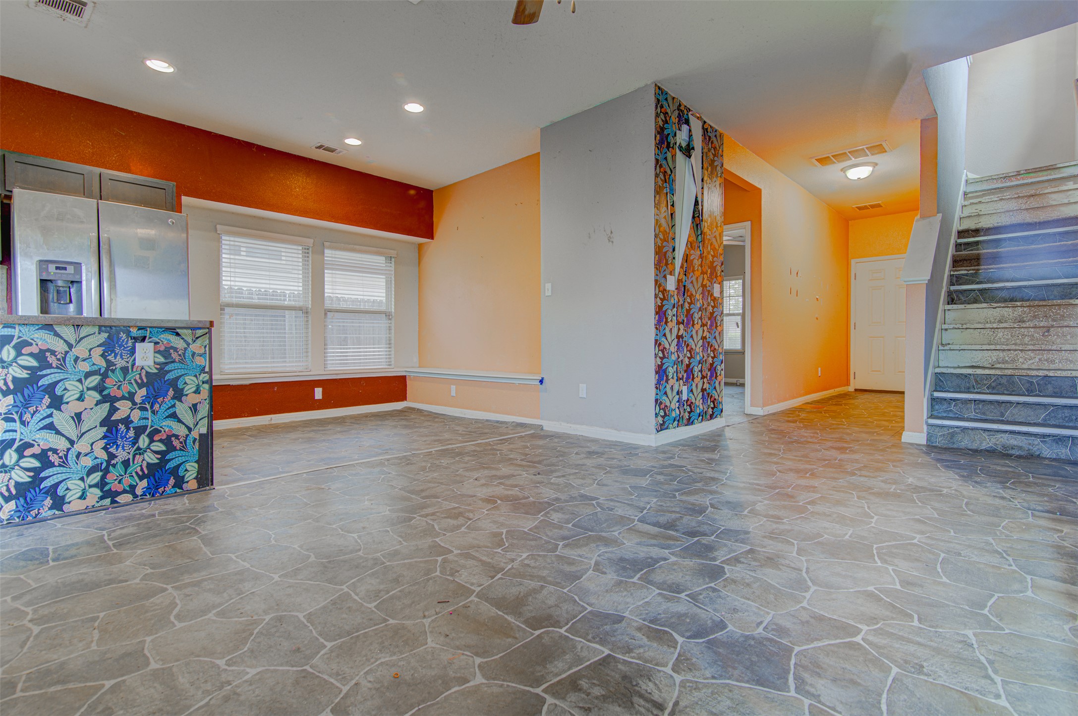 4527 Kind Way, Unit 231 Austin, TX 78725 - Photo 4 of 18 Open-concept living space featuring stone-patterned flooring, recessed lighting, and a vibrant accent wall