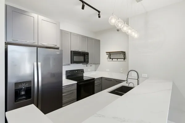 a kitchen with stainless steel appliances a refrigerator a sink and microwave
