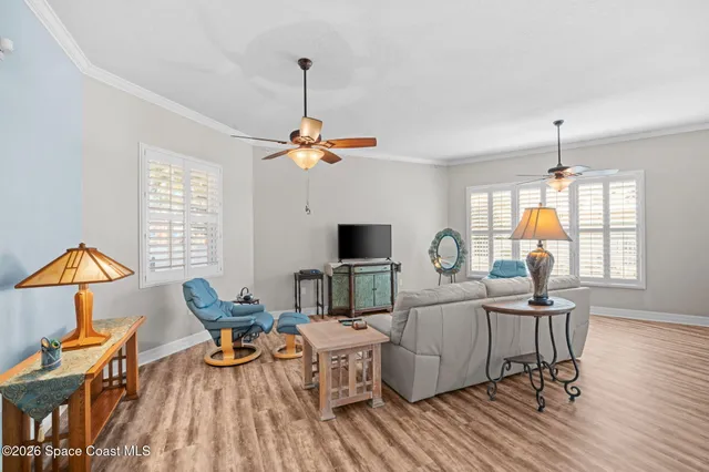 a living room with furniture a chandelier and a flat screen tv