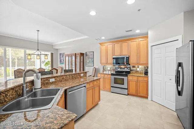 a kitchen with stainless steel appliances granite countertop a stove refrigerator sink and white cabinets