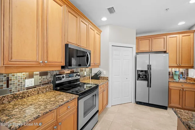 a kitchen with stainless steel appliances granite countertop a refrigerator stove and sink
