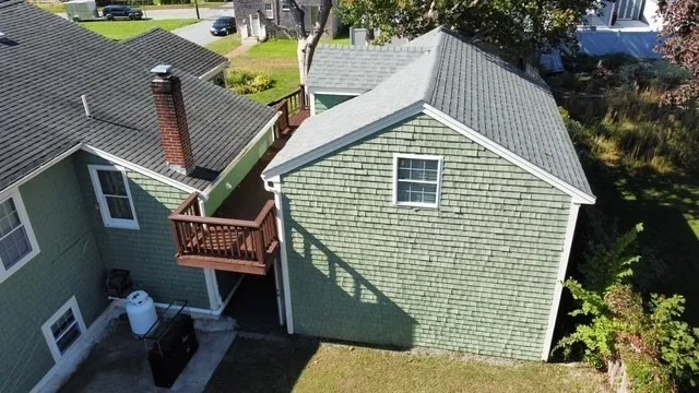 a view of a house with a wooden deck and furniture