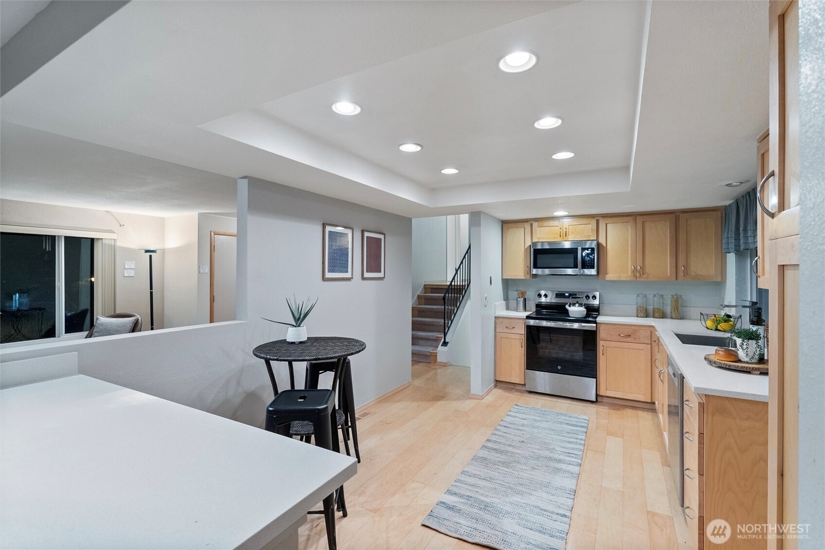 15618 Southeast 174th Street Renton, WA 98058 - Photo 8 of 28 a kitchen with microwave a stove and chairs