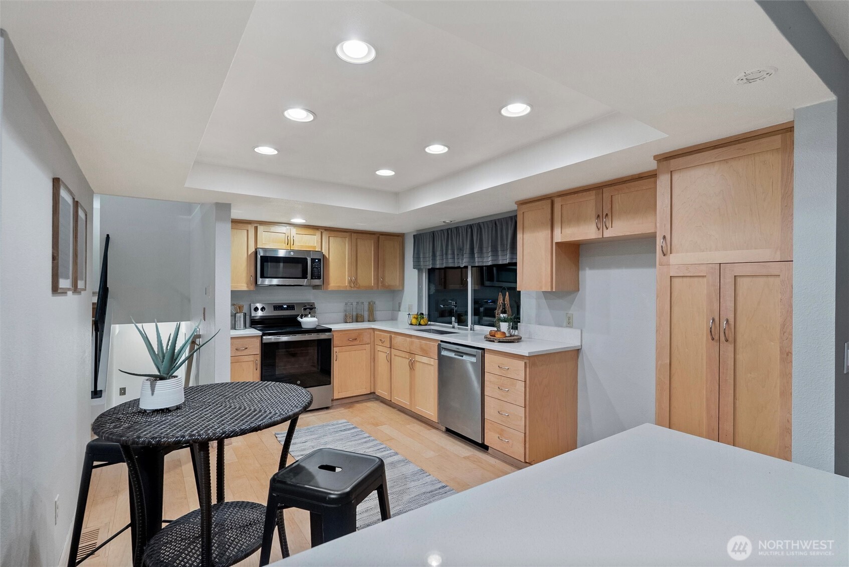 15618 Southeast 174th Street Renton, WA 98058 - Photo 10 of 28 a kitchen with a table chairs microwave and cabinets
