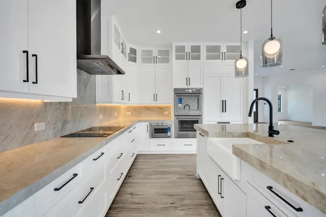 a bathroom with a granite countertop sink a mirror and a bathtub
