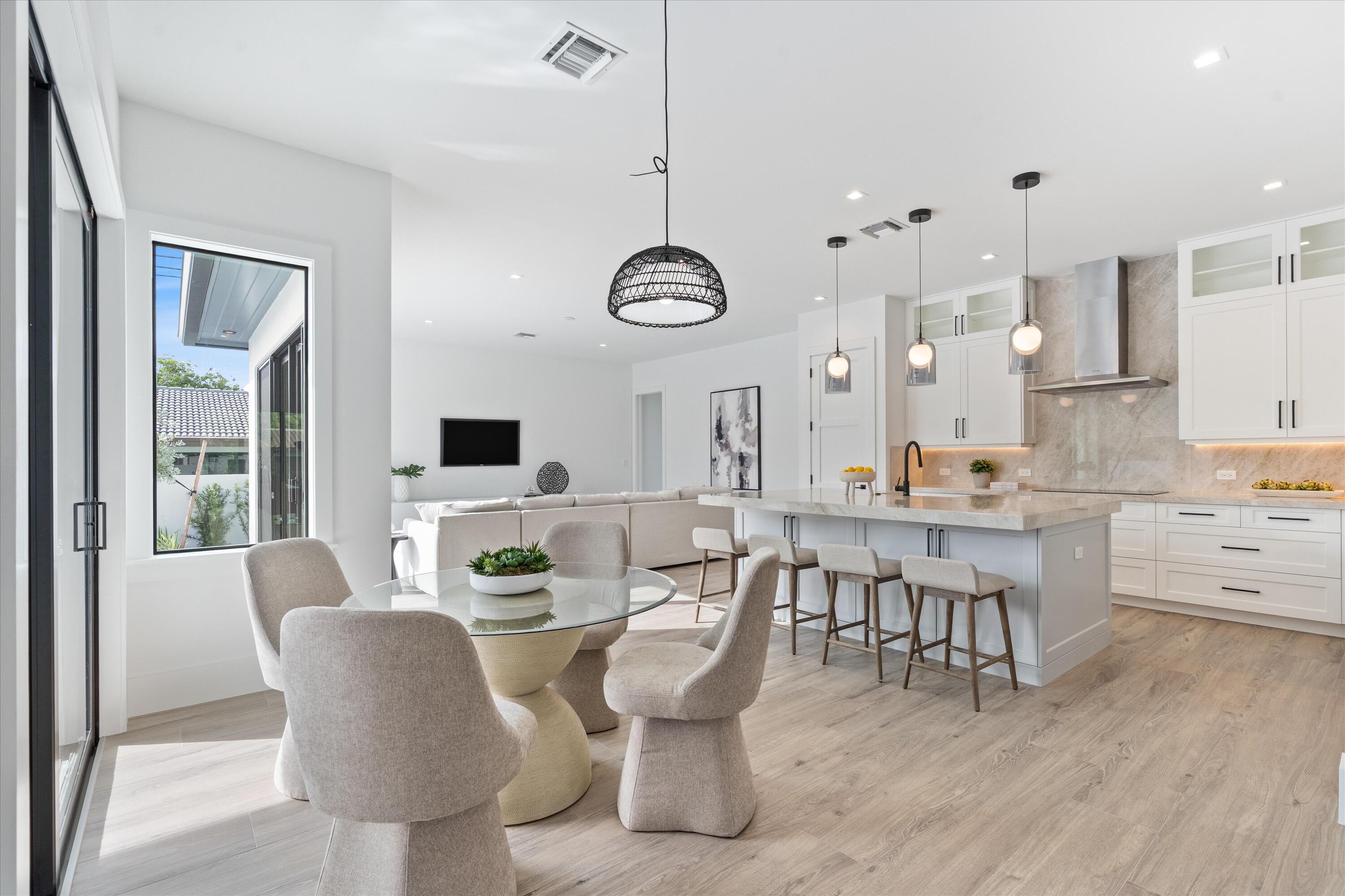 4451 Northeast 27th Terrace Lighthouse Point, FL 33064 - Photo 12 of 38 a dining room with furniture a chandelier and wooden floor
