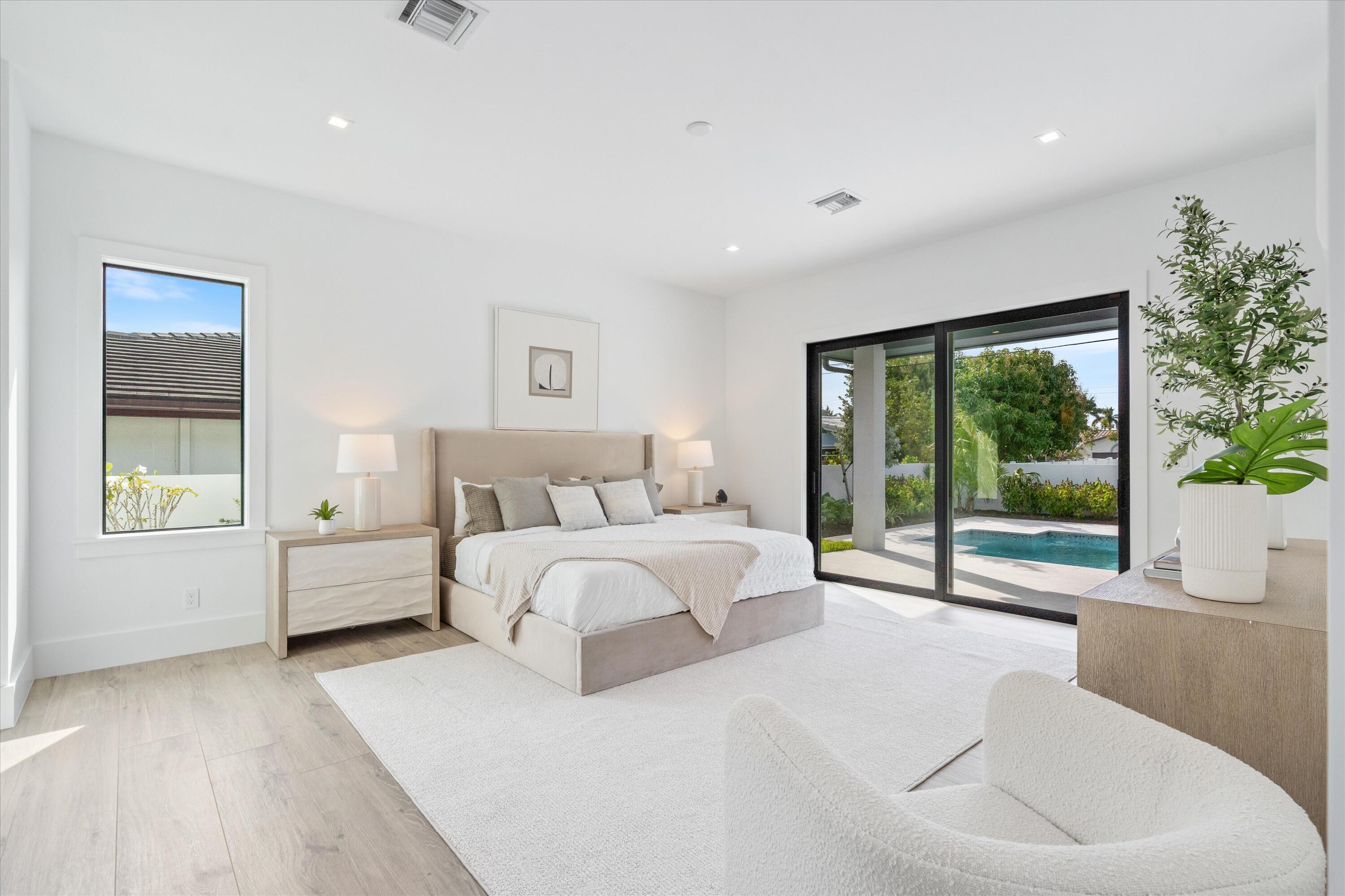 4451 Northeast 27th Terrace Lighthouse Point, FL 33064 - Photo 15 of 38 a spacious bedroom with a large bed and a large window