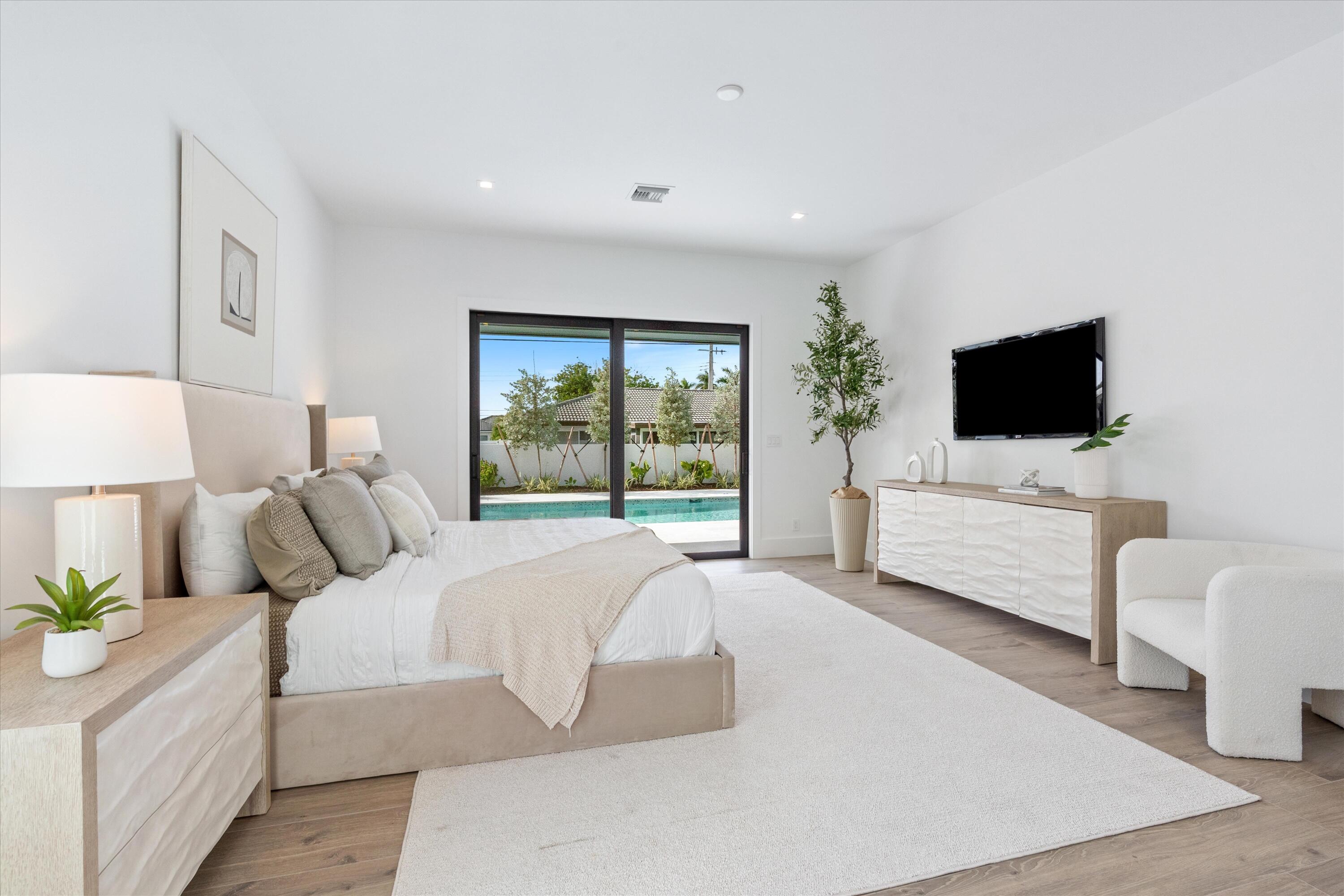 4451 Northeast 27th Terrace Lighthouse Point, FL 33064 - Photo 16 of 38 a bedroom with bed tv and window