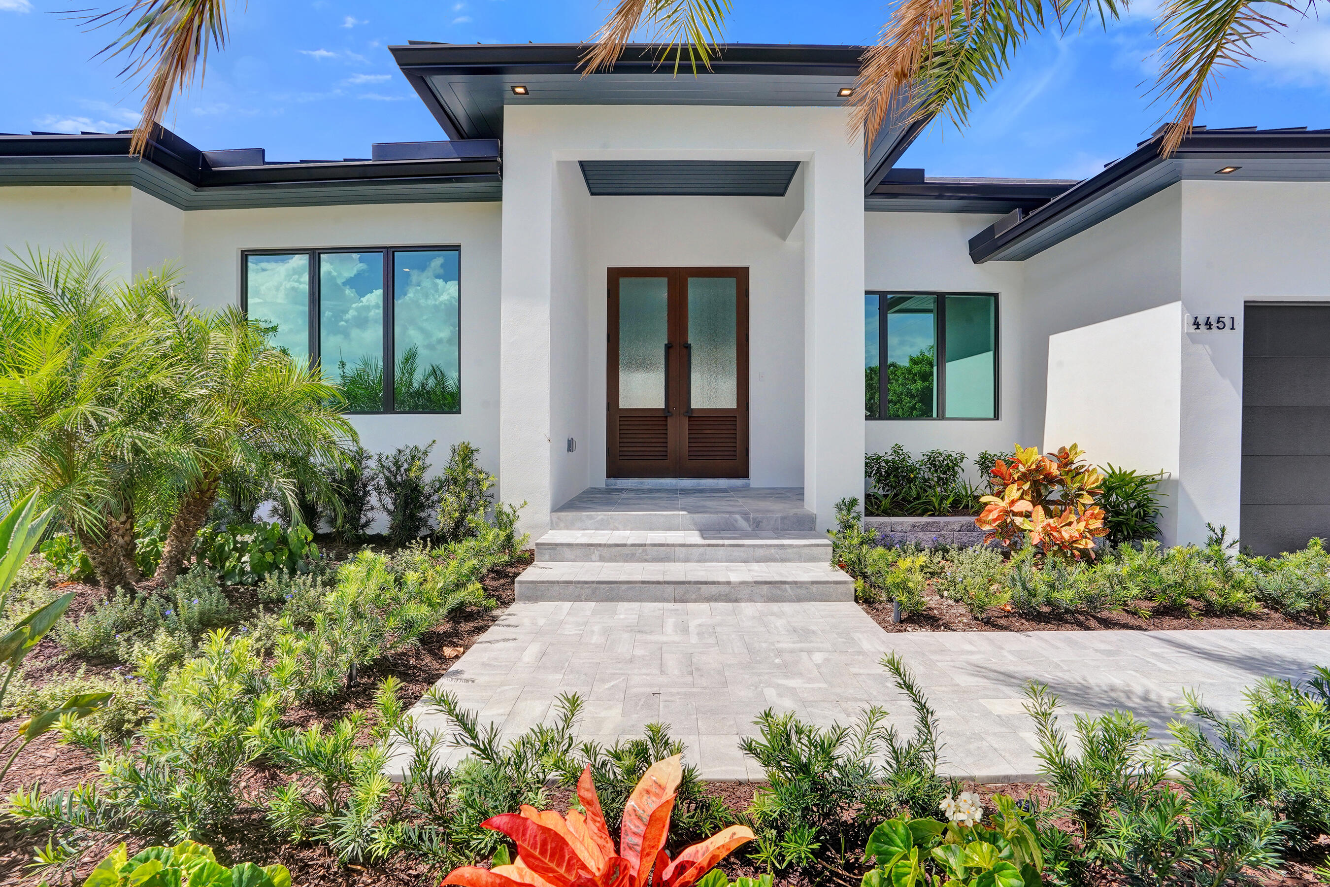 4451 Northeast 27th Terrace Lighthouse Point, FL 33064 - Photo 2 of 38 a front view of a house with a yard