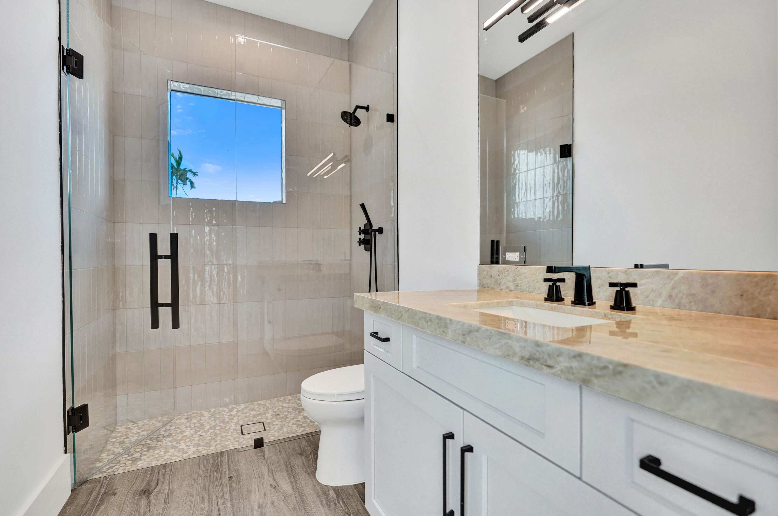 4451 Northeast 27th Terrace Lighthouse Point, FL 33064 - Photo 21 of 38 a bathroom with a granite countertop sink mirror vanity and toilet