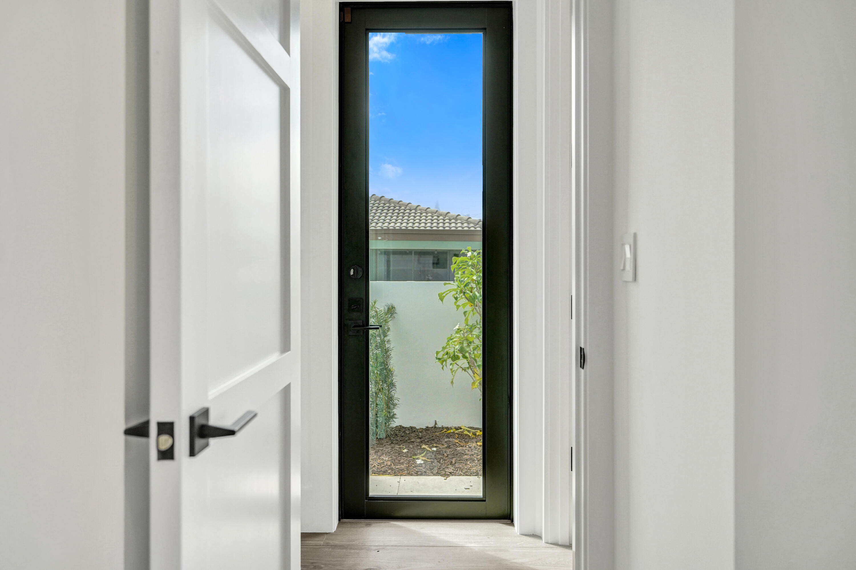 4451 Northeast 27th Terrace Lighthouse Point, FL 33064 - Photo 27 of 38 a view of a hallway with wooden floor and door