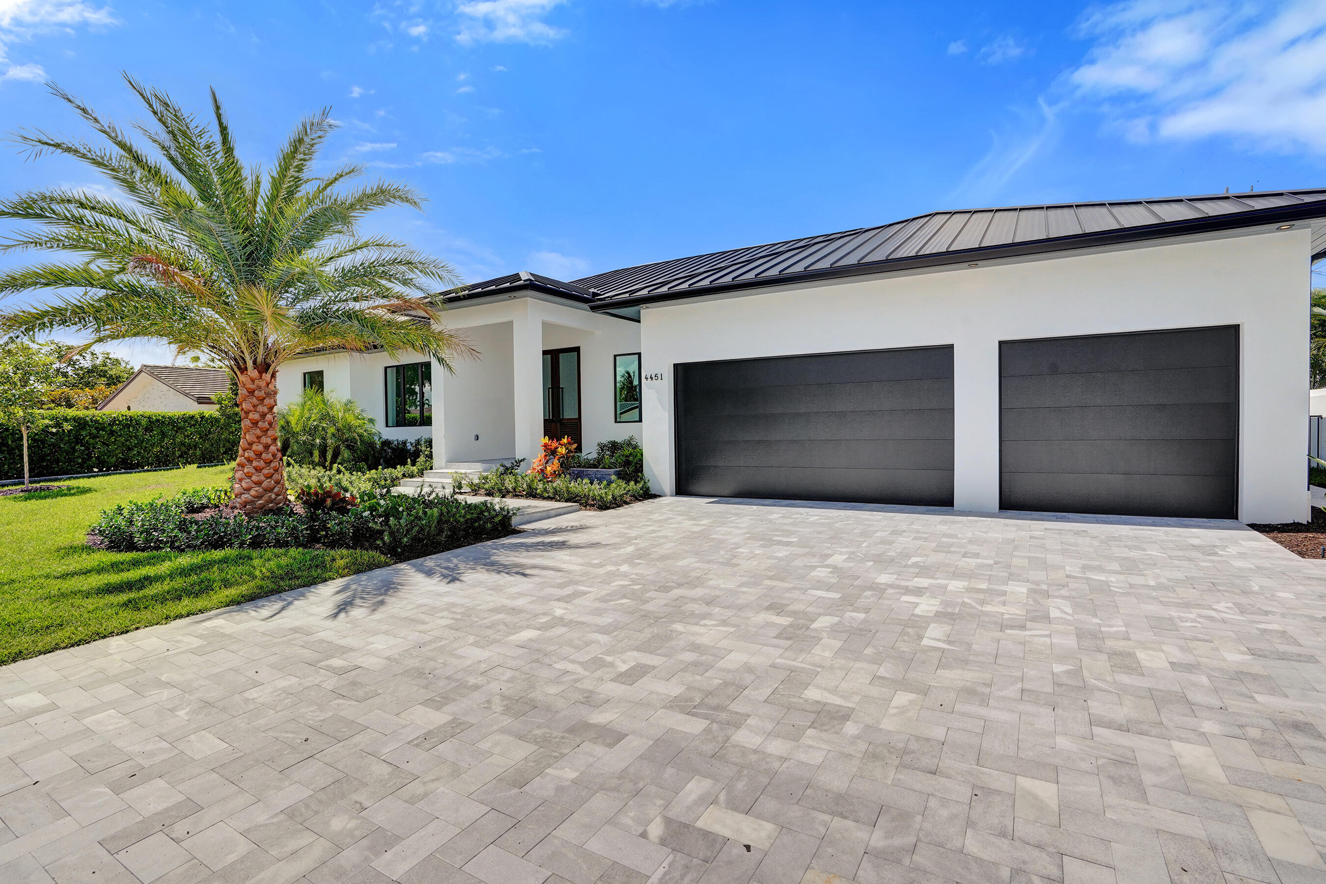 4451 Northeast 27th Terrace Lighthouse Point, FL 33064 - Photo 35 of 38 a front view of a house with a yard and garage