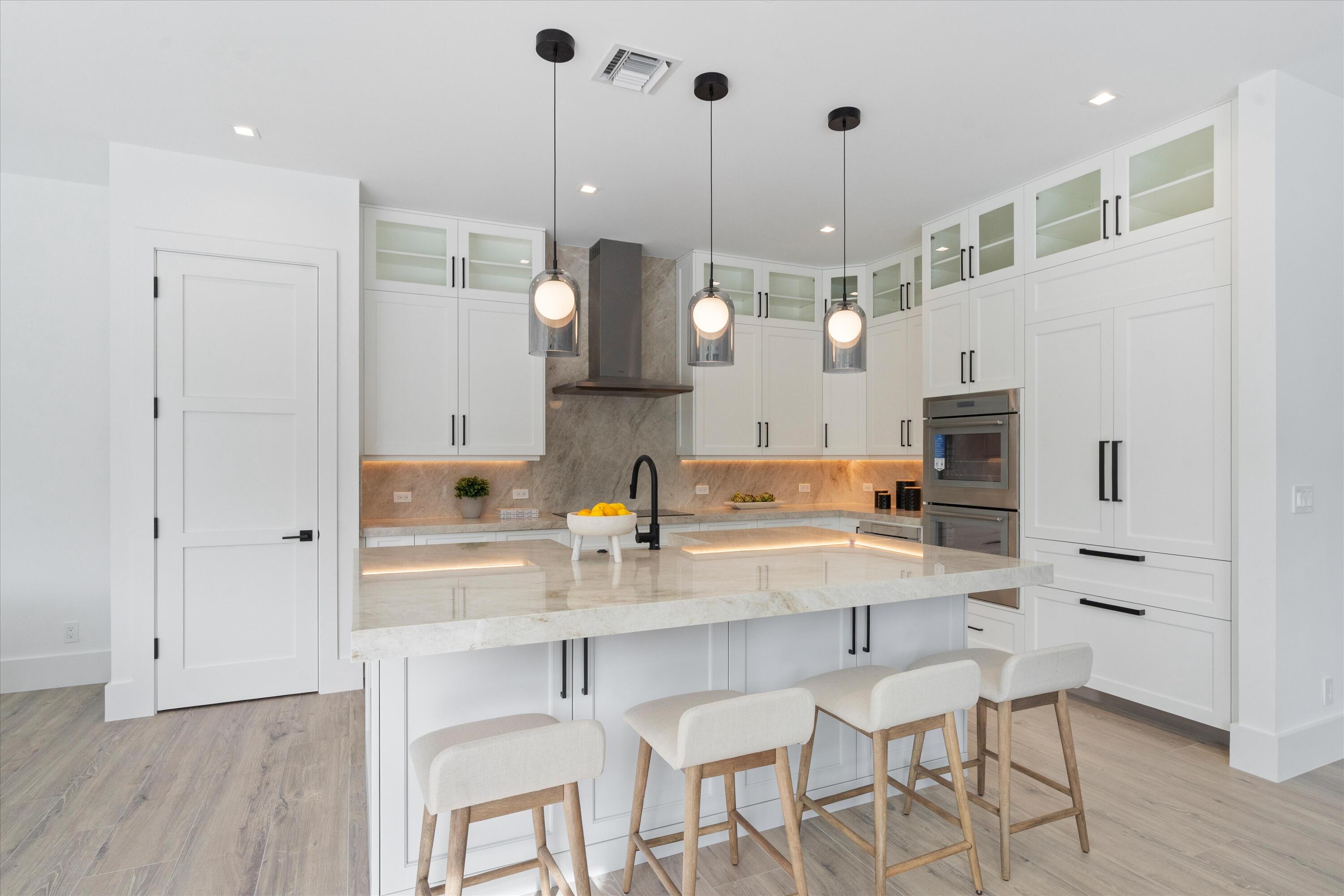 4451 Northeast 27th Terrace Lighthouse Point, FL 33064 - Photo 10 of 38 a kitchen with white cabinets and stainless steel appliances