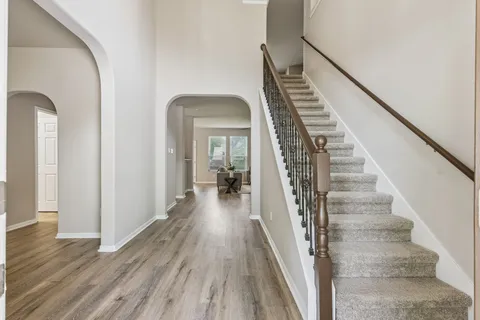 a view of a hallway with wooden floor and staircase