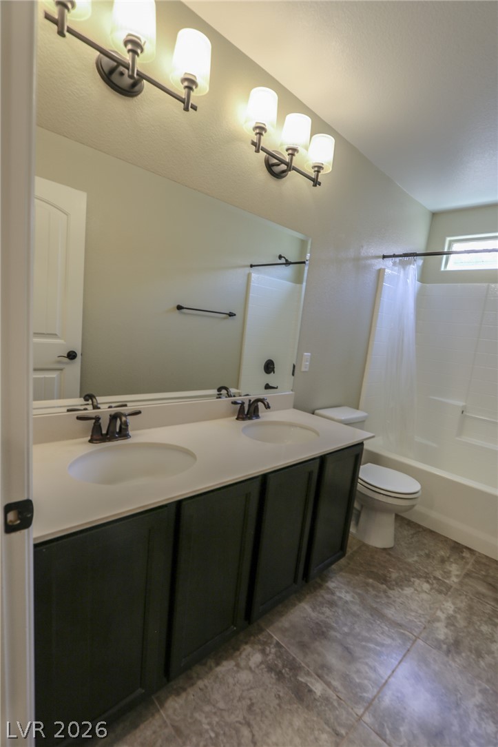 1509 Destiny Ridge Court Henderson, NV 89074 - Photo 17 of 29 Stone-look tile floors support a long dark vanity in this functional bathroom layout.