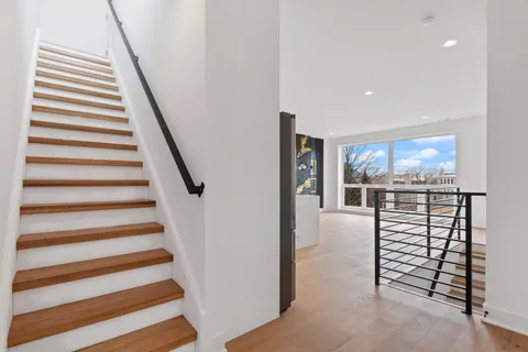 a view of a hallway with stairs and a fireplace