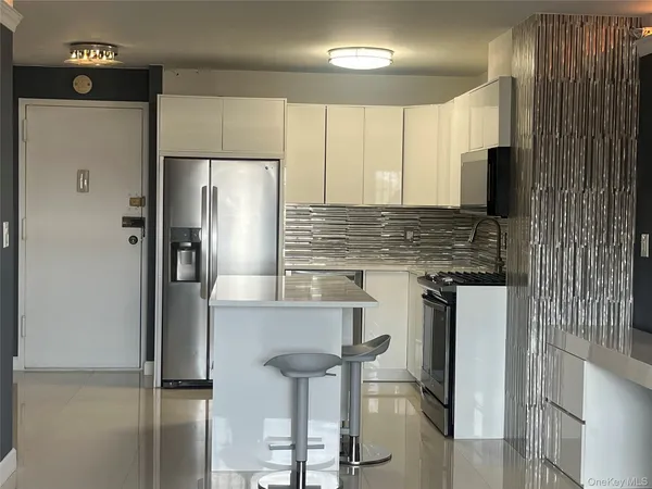 a kitchen with stainless steel appliances granite countertop a refrigerator and a stove