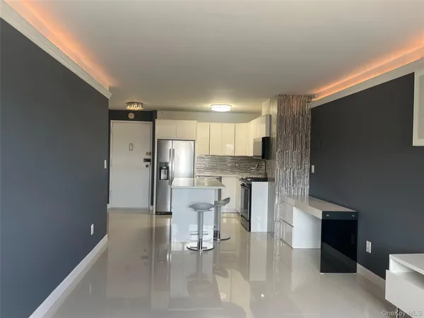 a kitchen with stainless steel appliances kitchen island granite countertop a refrigerator and cabinets