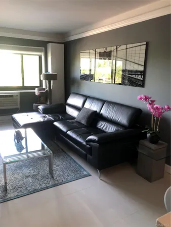 a living room with furniture and a floor to ceiling window