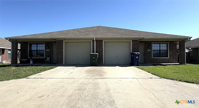 a backyard of a house with dishwasher and wooden fence