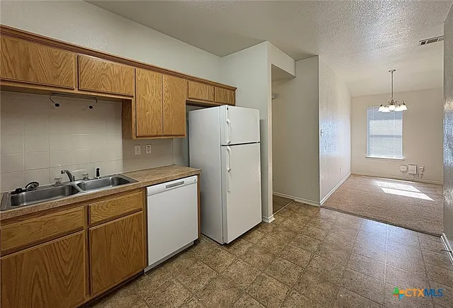 a kitchen with a refrigerator sink and cabinets
