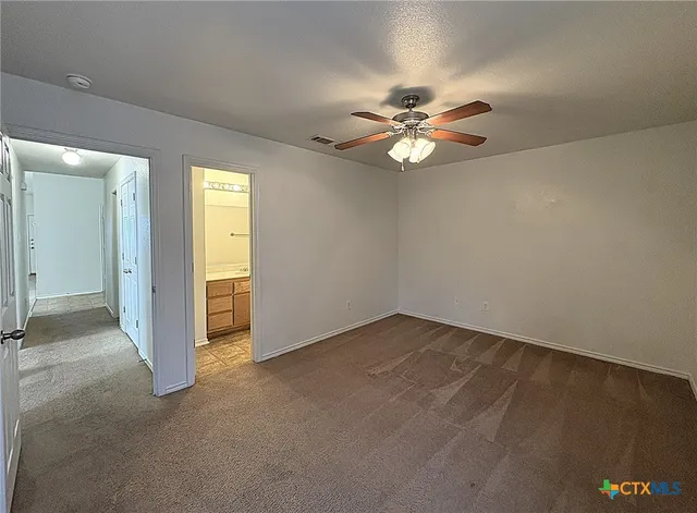 an empty room with closet and a chandelier fan