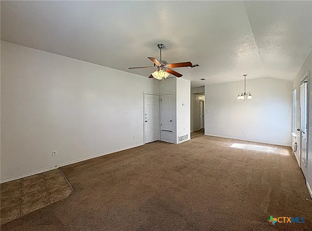 an empty room with a ceiling fan and window
