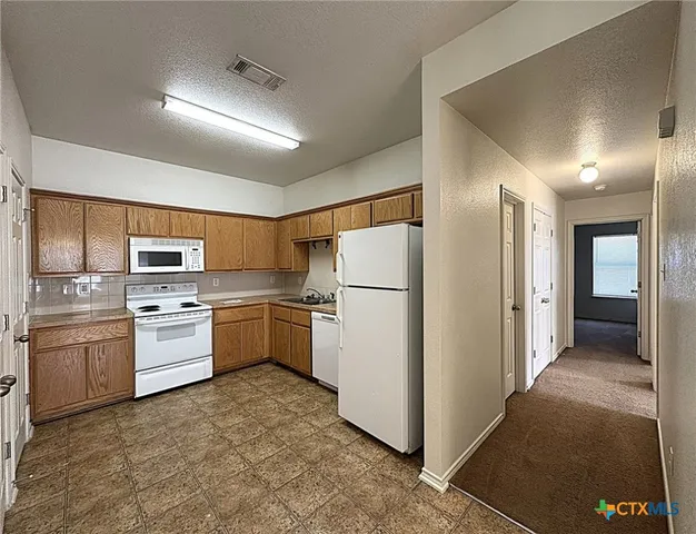 a kitchen with a refrigerator stove and oven