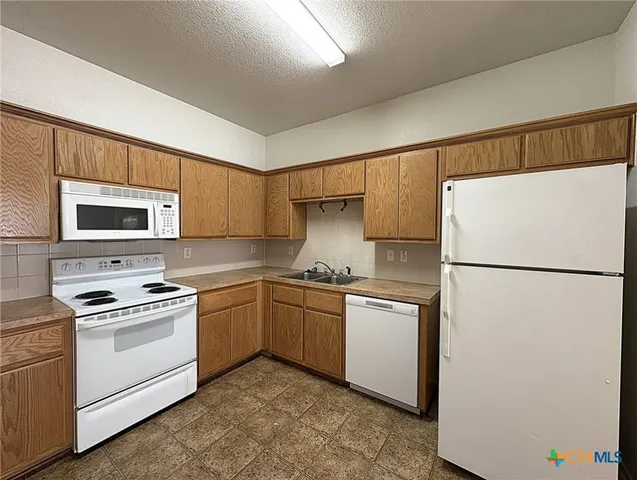 a kitchen with a refrigerator sink and stove