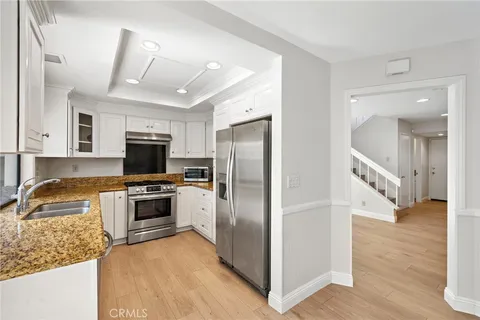 a kitchen with stainless steel appliances granite countertop a refrigerator a stove a sink and a microwave