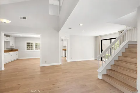 a view of an entryway with wooden floor and a kitchen view
